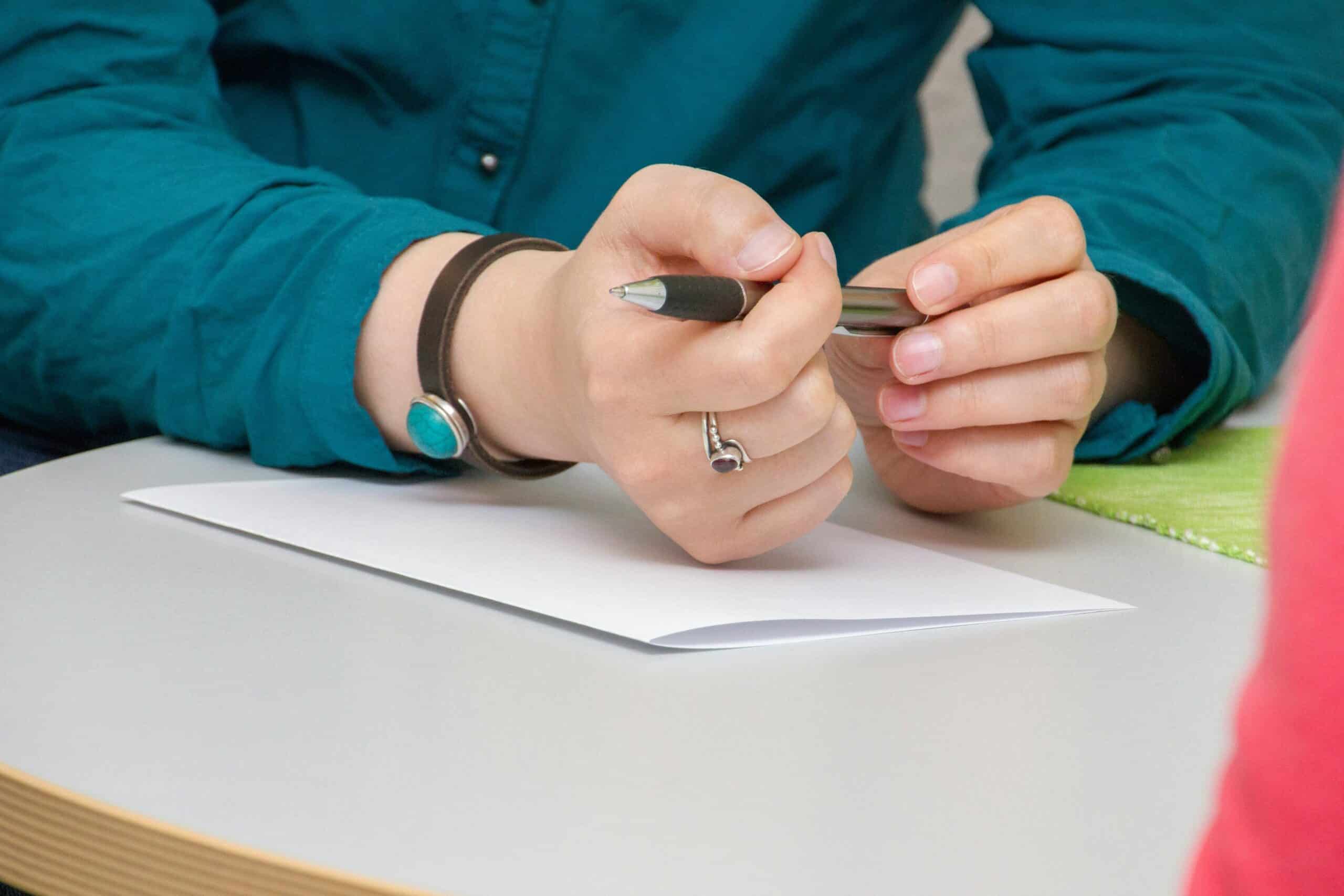 Hands holding a pen, preparing to write