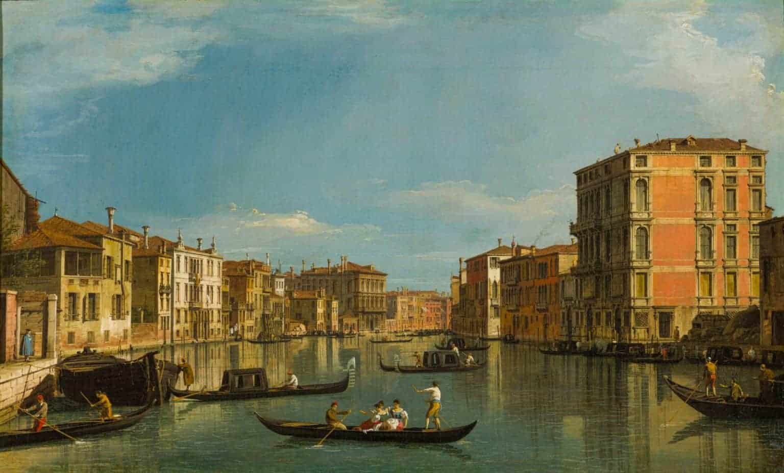 A view of a gondala on water in the foreground and Venice in the background