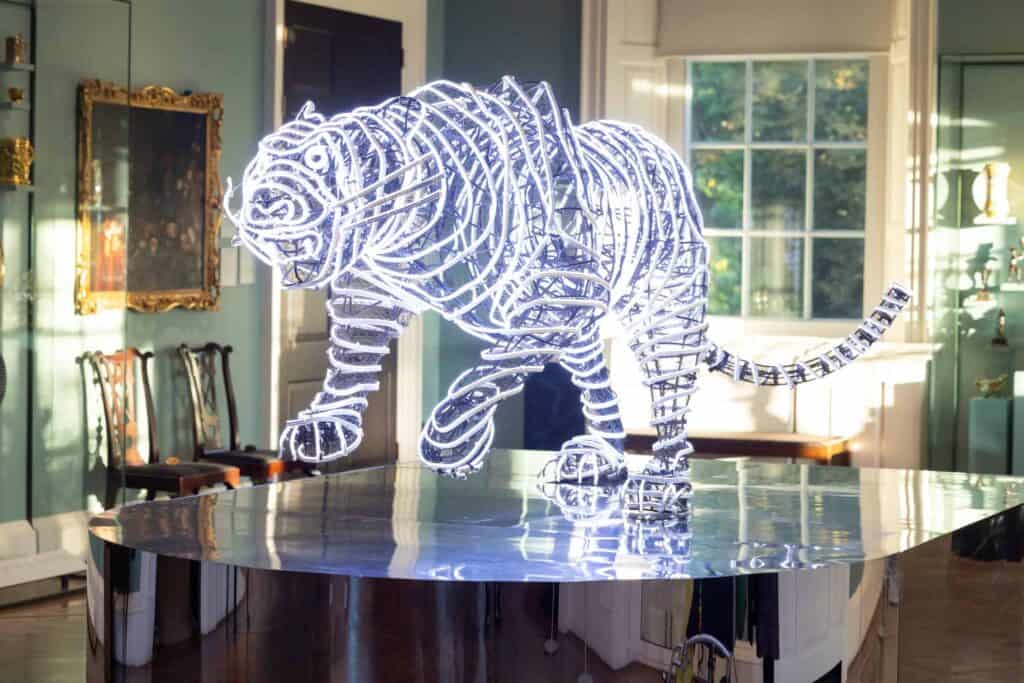 A neon tiger sculpture on a glass table in the Holburne ballroom