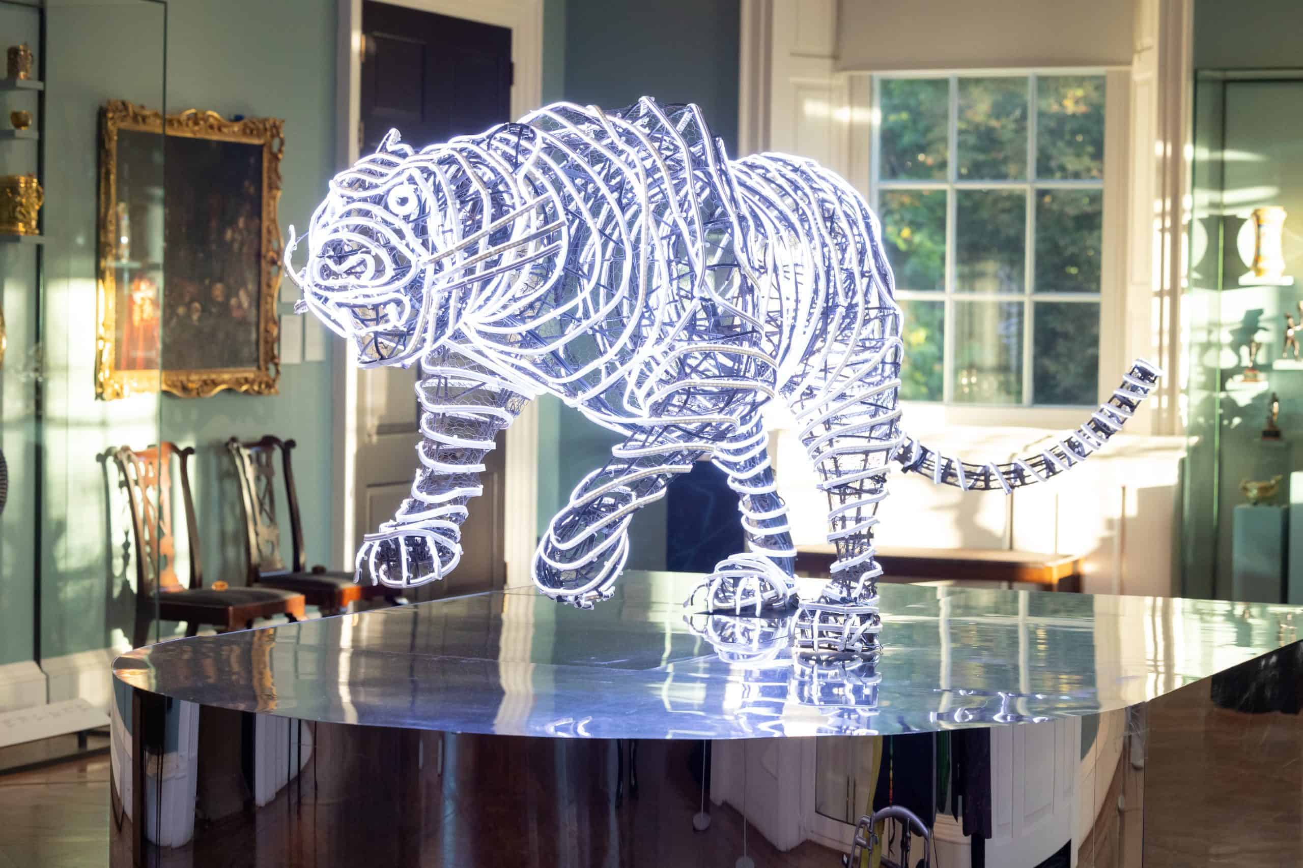 A neon tiger sculpture on a glass table in the Holburne ballroom