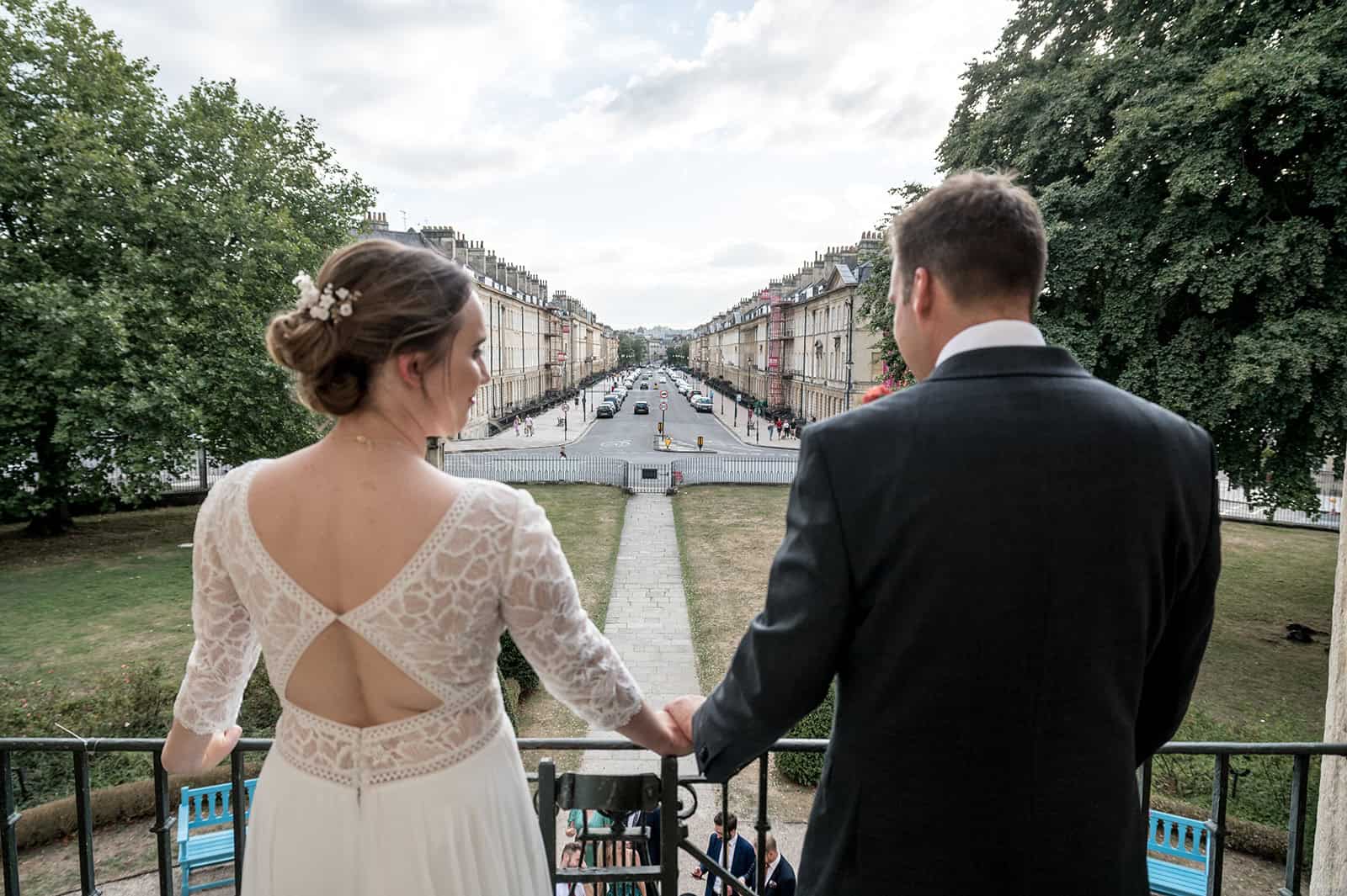 Photo showing a newly married couple standing on the balcony of the museum looking at the view down a wide Georgian street