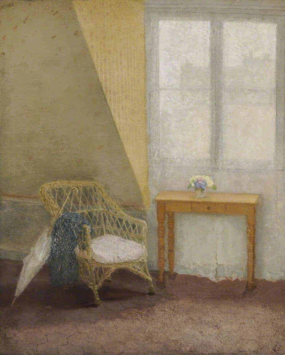 A wicker chair next to a table by a window in typical Gwen John muted colours