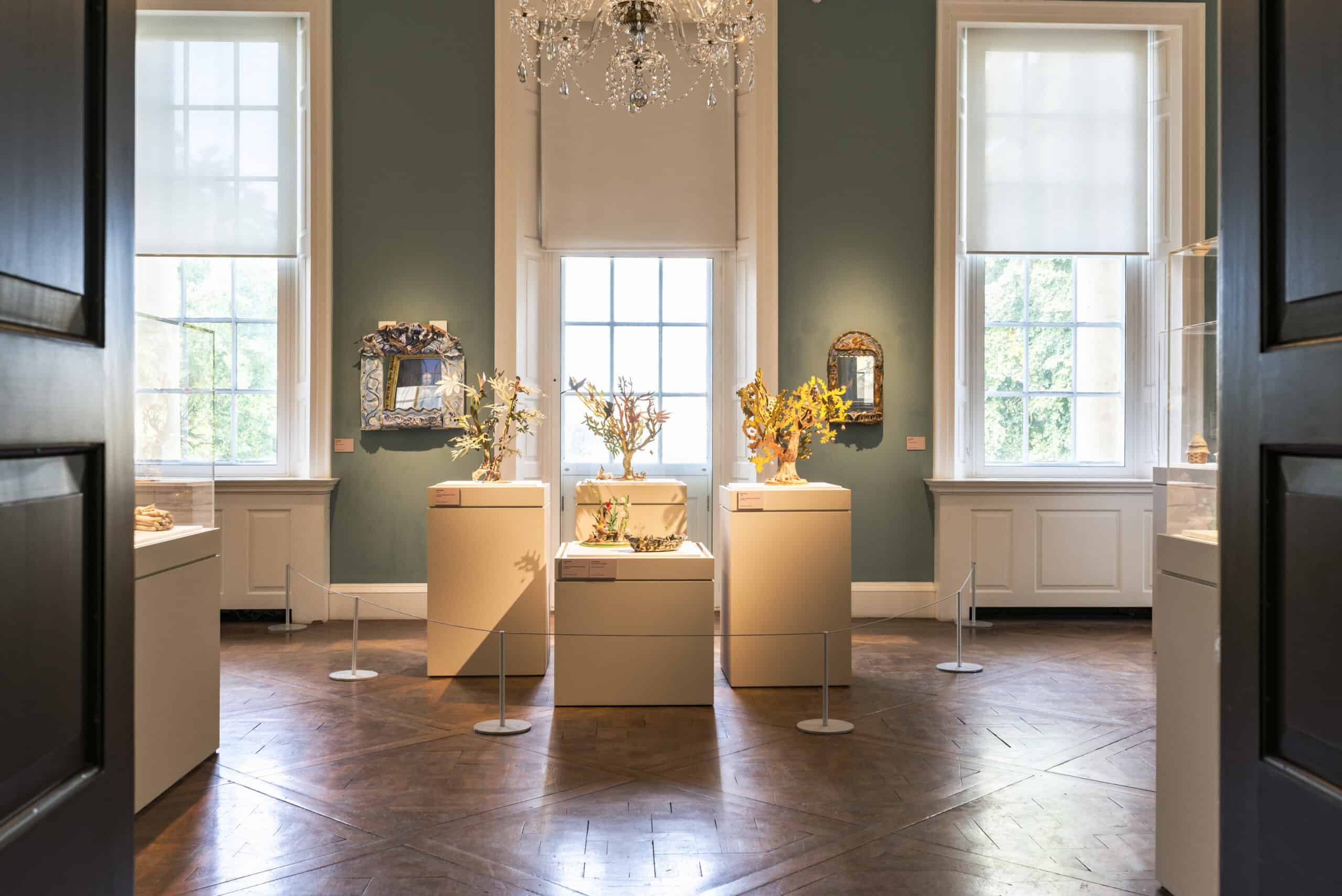 Sculptures of trees on white plinths in the Holburne ballroom