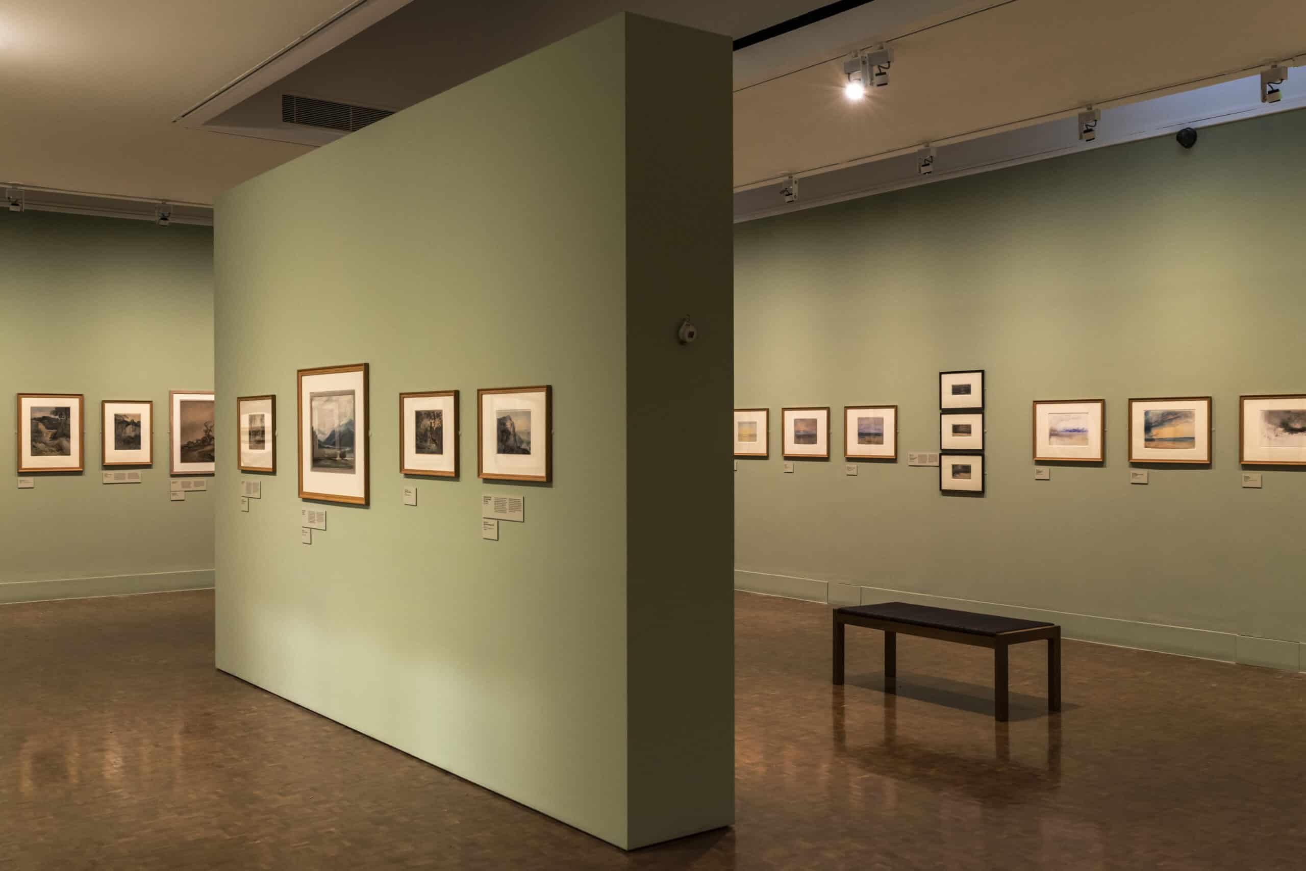 A gallery installation photograph of Turner watercolours on green walls