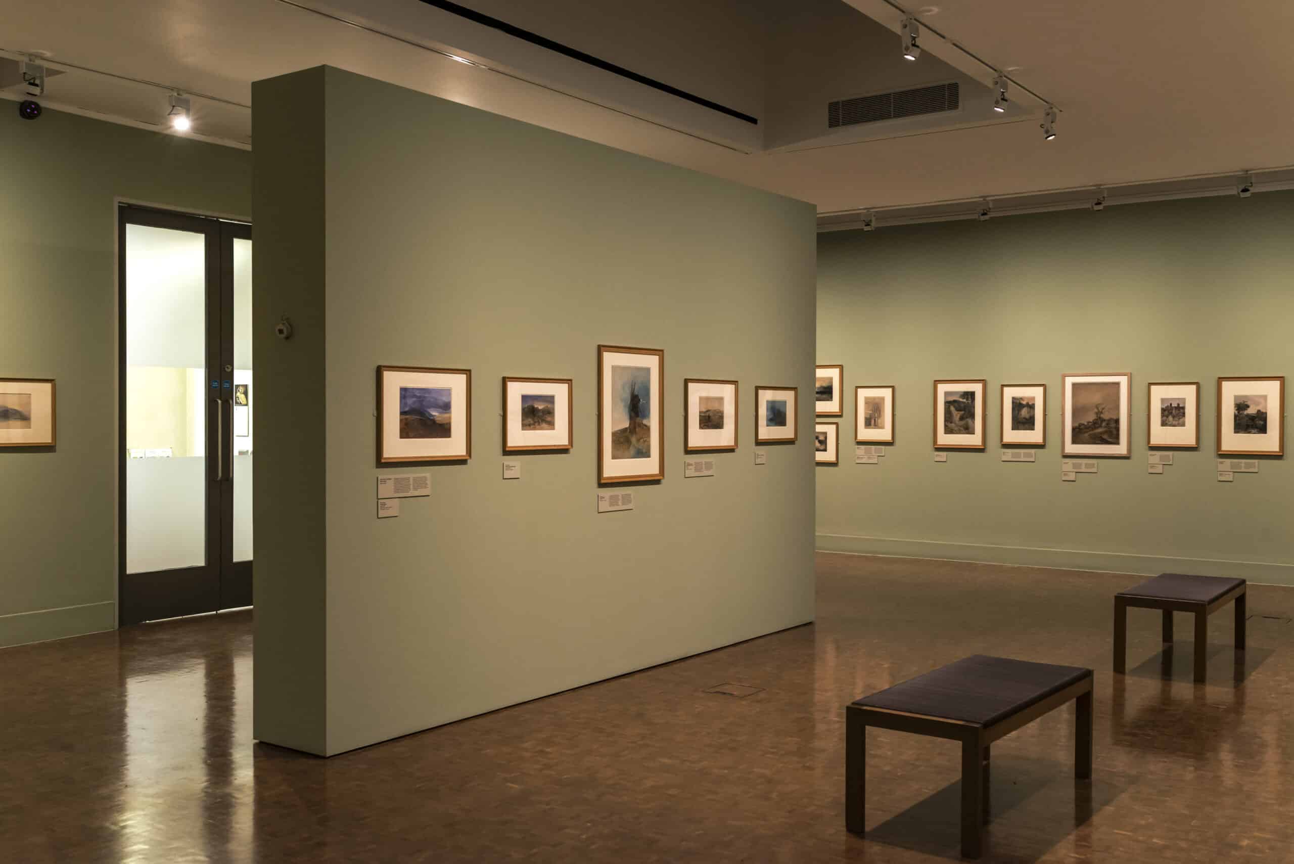 A gallery installation photograph of Turner watercolours on green walls
