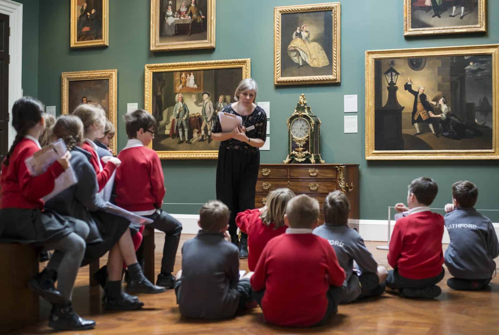 A school group of children, taking part in class in a gallery space at the Holburne Museum.