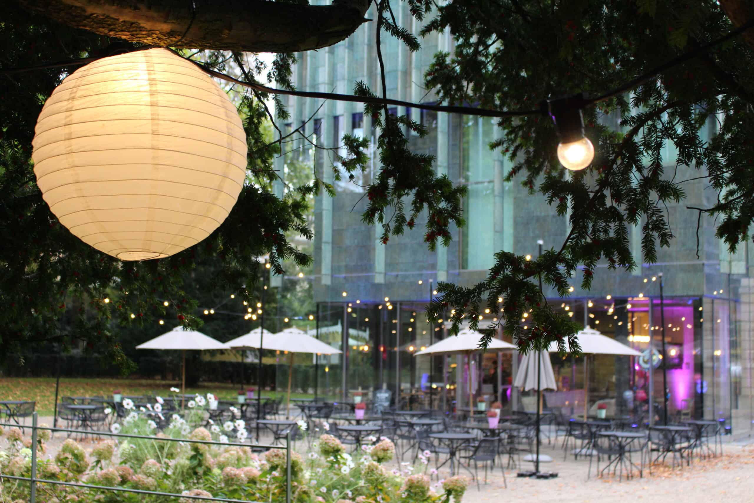 Photo showing the back of the Holburne museum and terrace lit up for an event with lanterns in the trees
