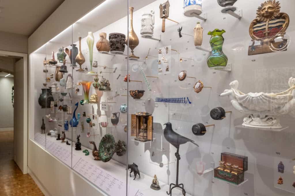 Display case in the Peckham Corridor exhibition featuring ceramics and decorative tiles from the Holburne Museum collection.