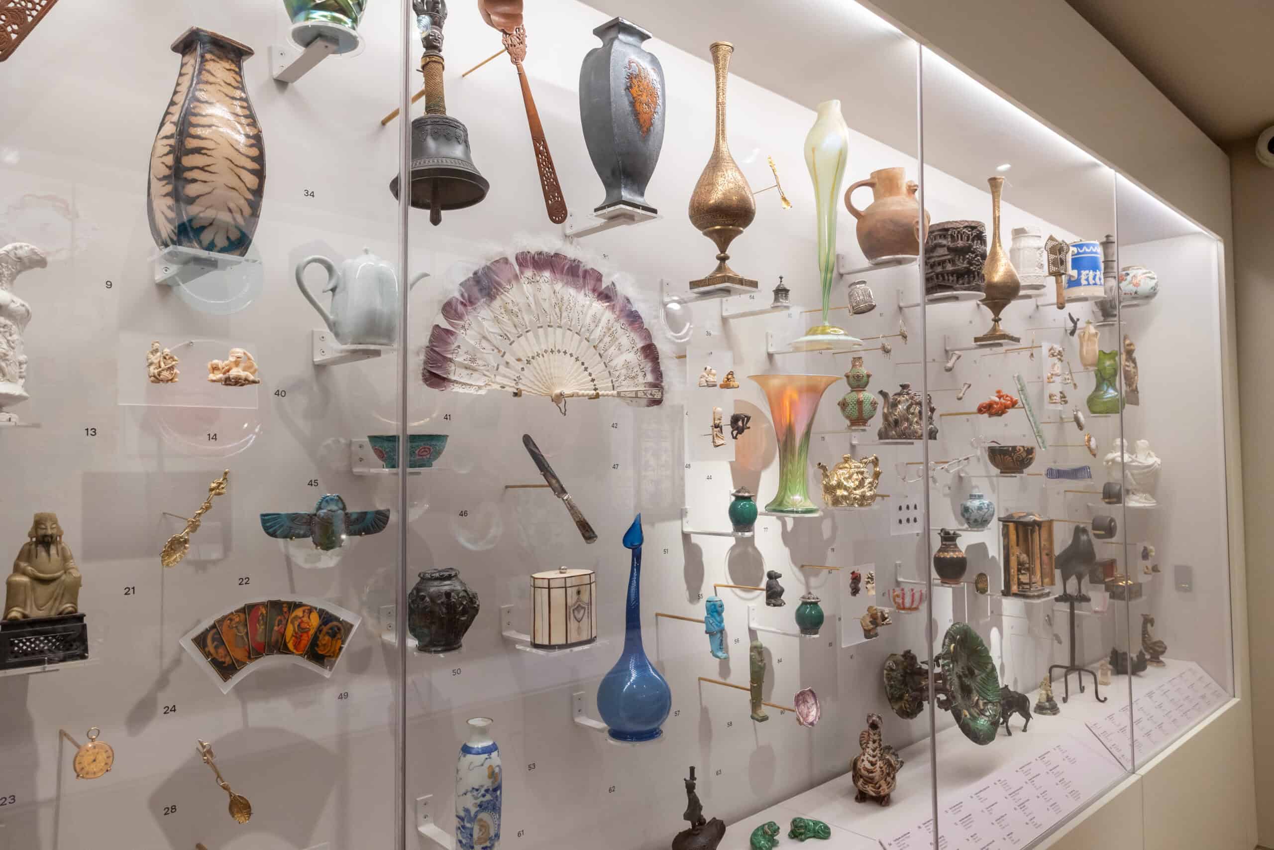 Display case in the Peckham Corridor exhibition featuring ceramics and decorative tiles from the Holburne Museum collection.