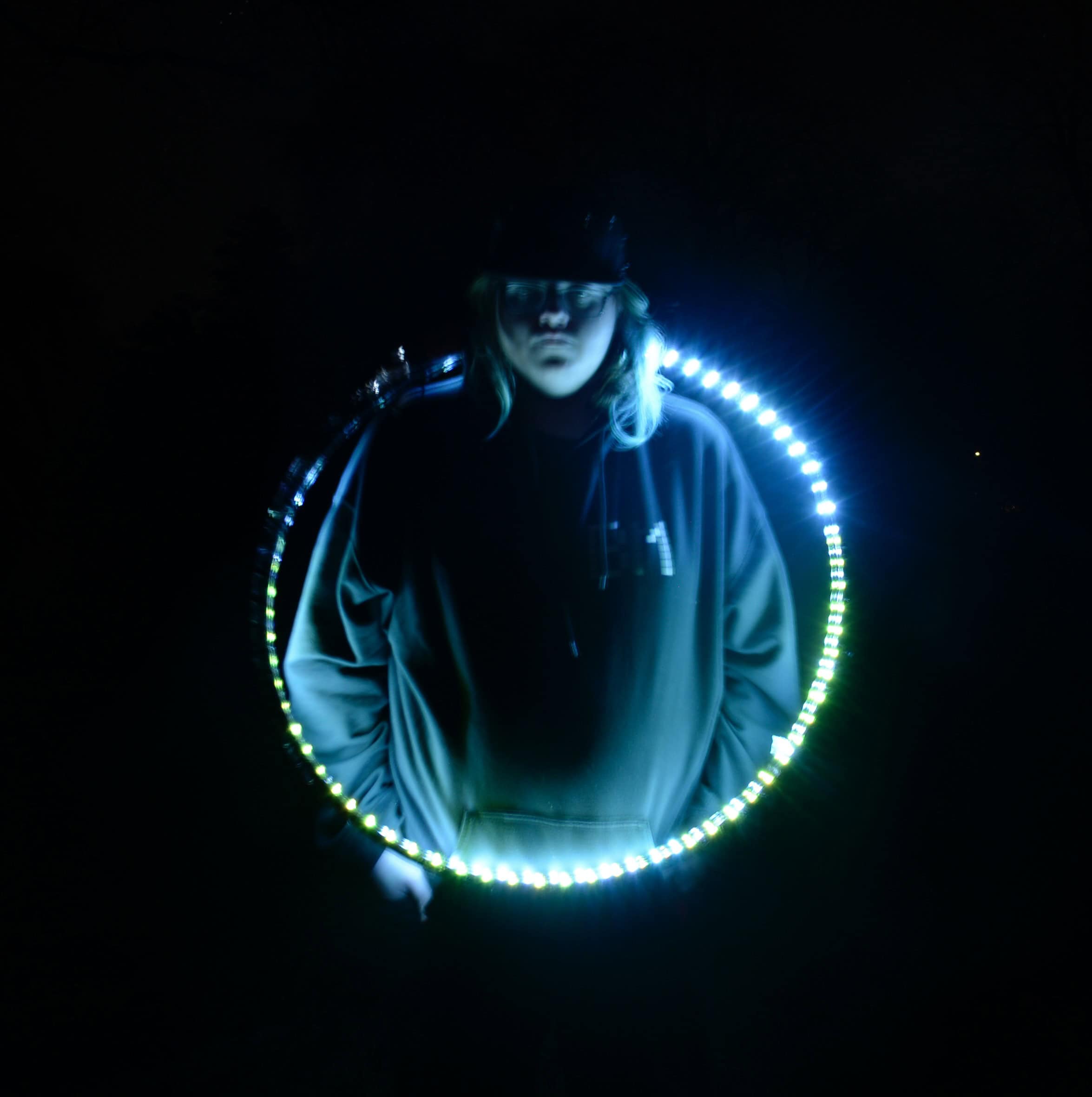 Child stop againast a dark black backround with a blue circle of light highlighting them.