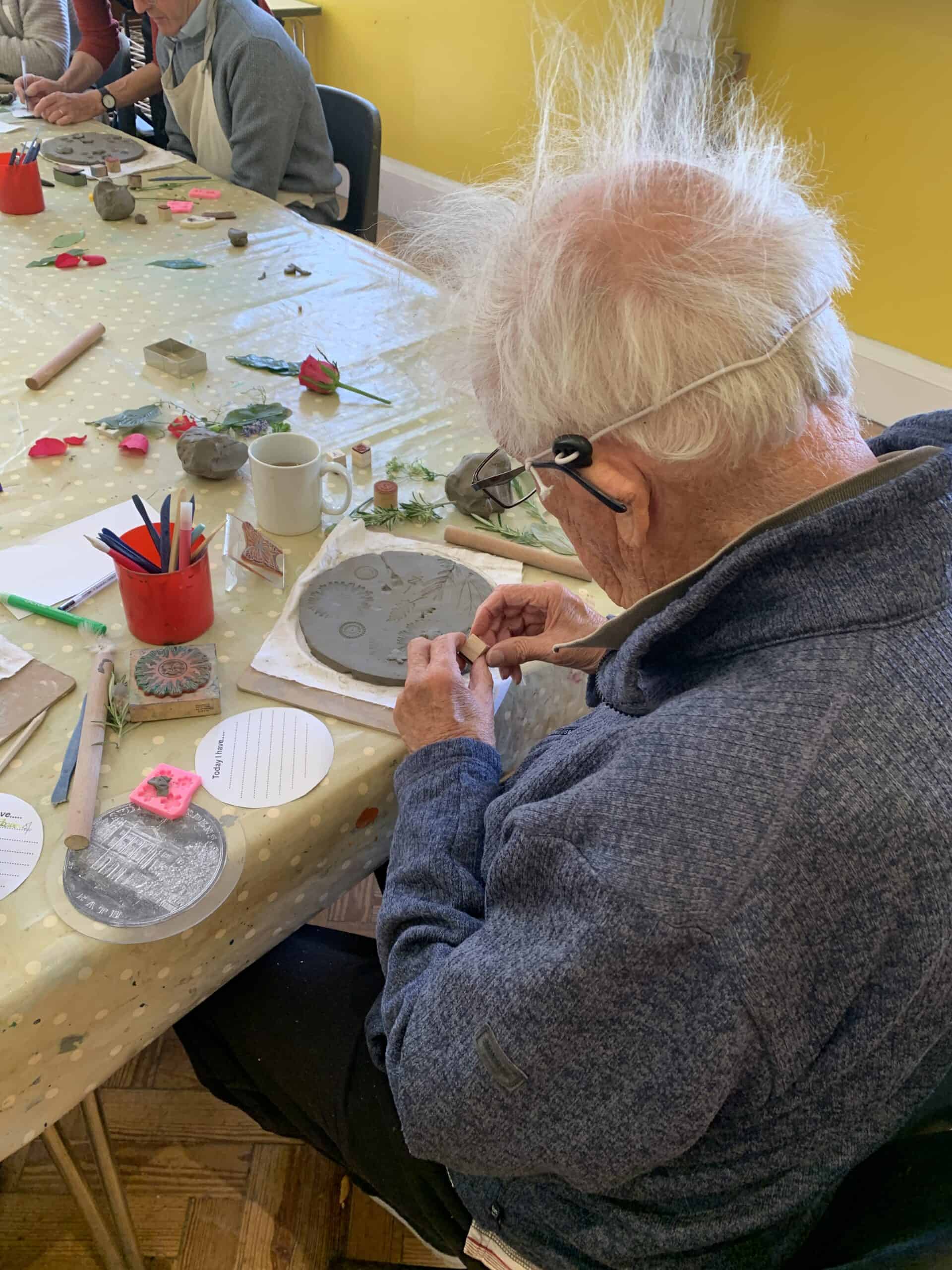 Elderly man taking part in a craft workshop.