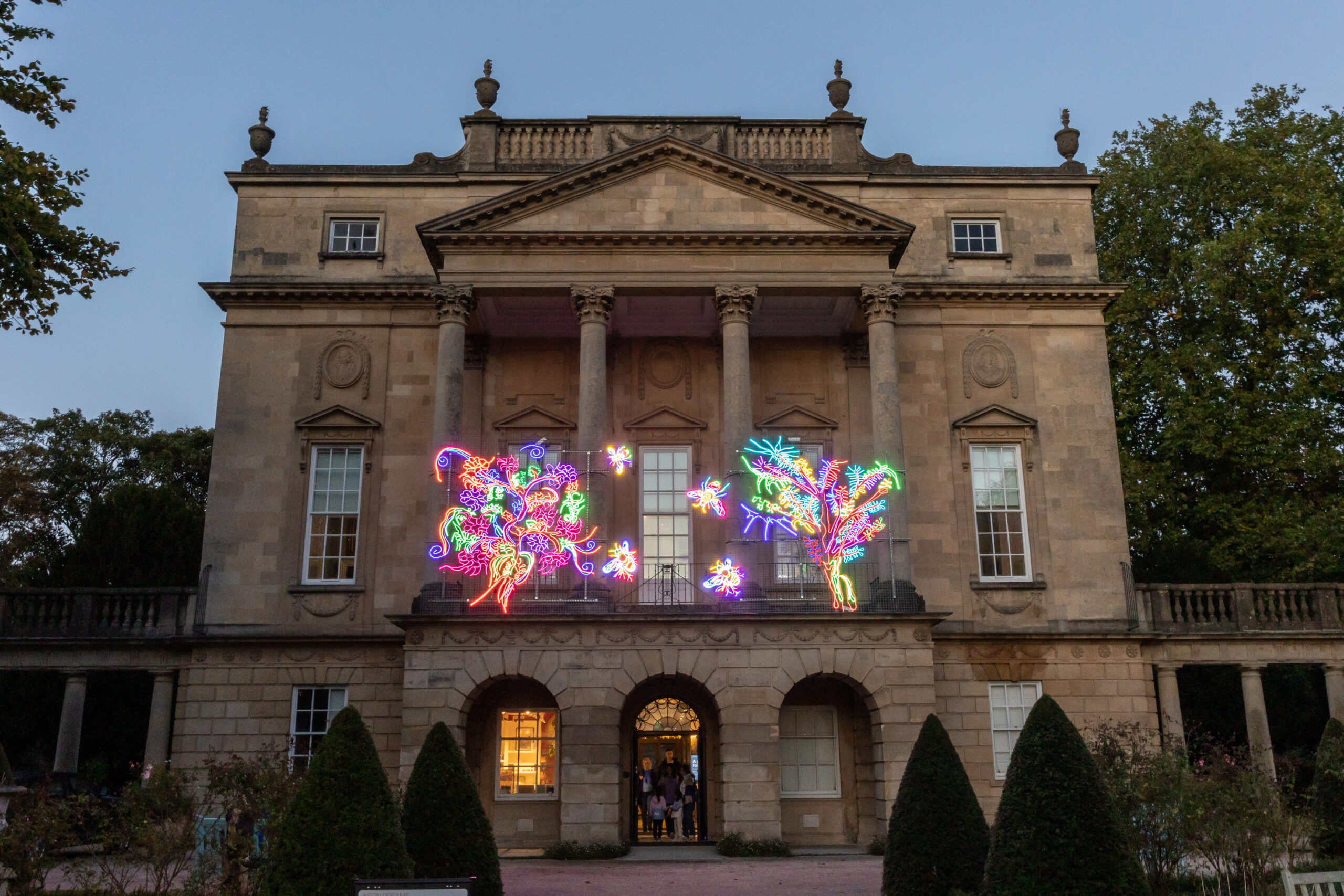 Photo showing the museum facade lit up by an artwork of neon trees